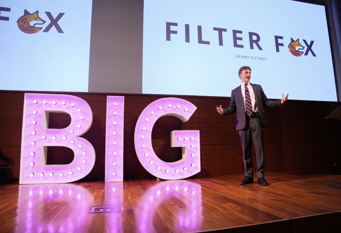 Henry Putney presenting on stage at the Powers Pitch Competition